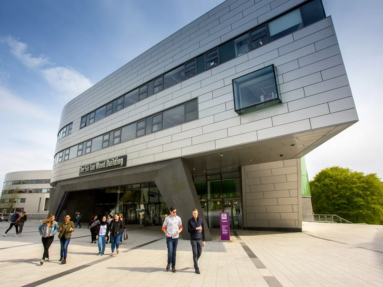 students walking out of sir ian wood building