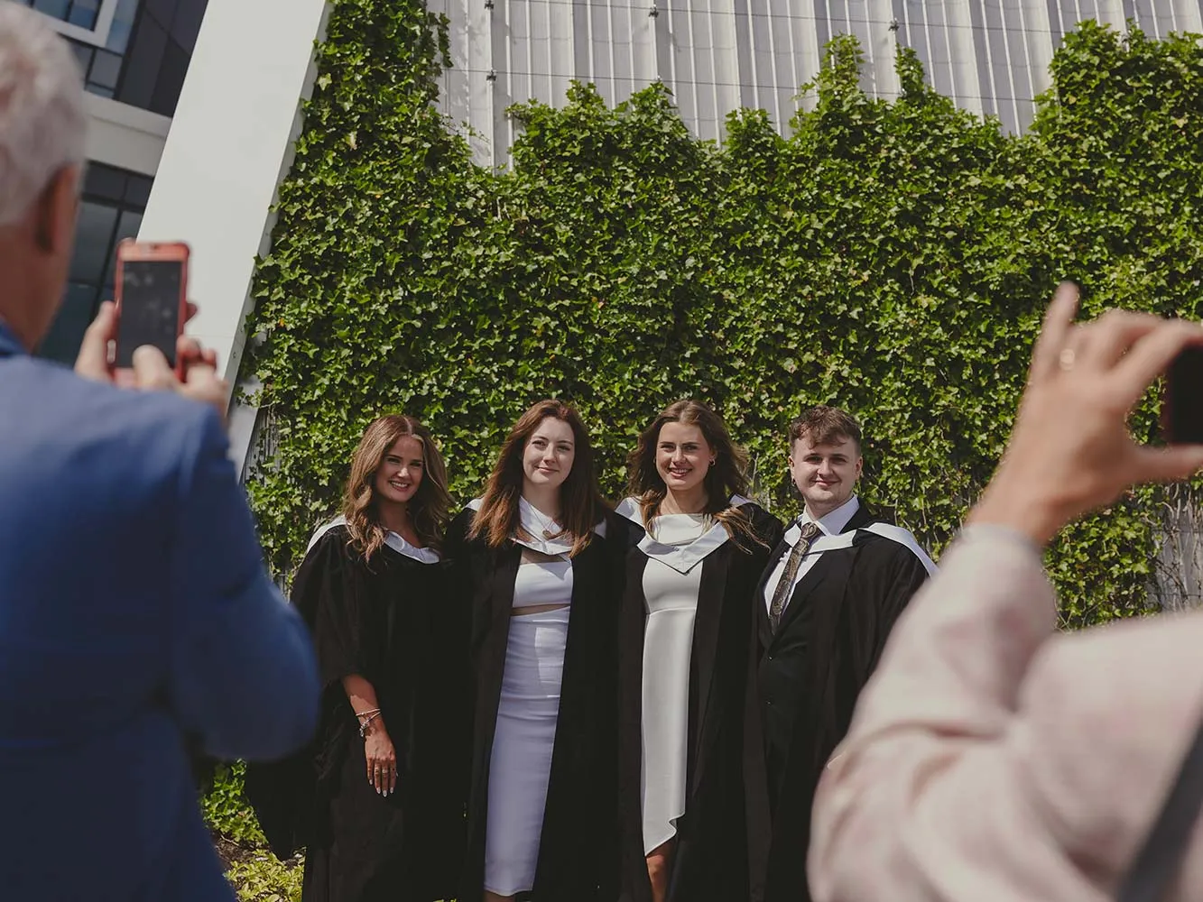 4 graduates getting photographs taken outside P&J Live