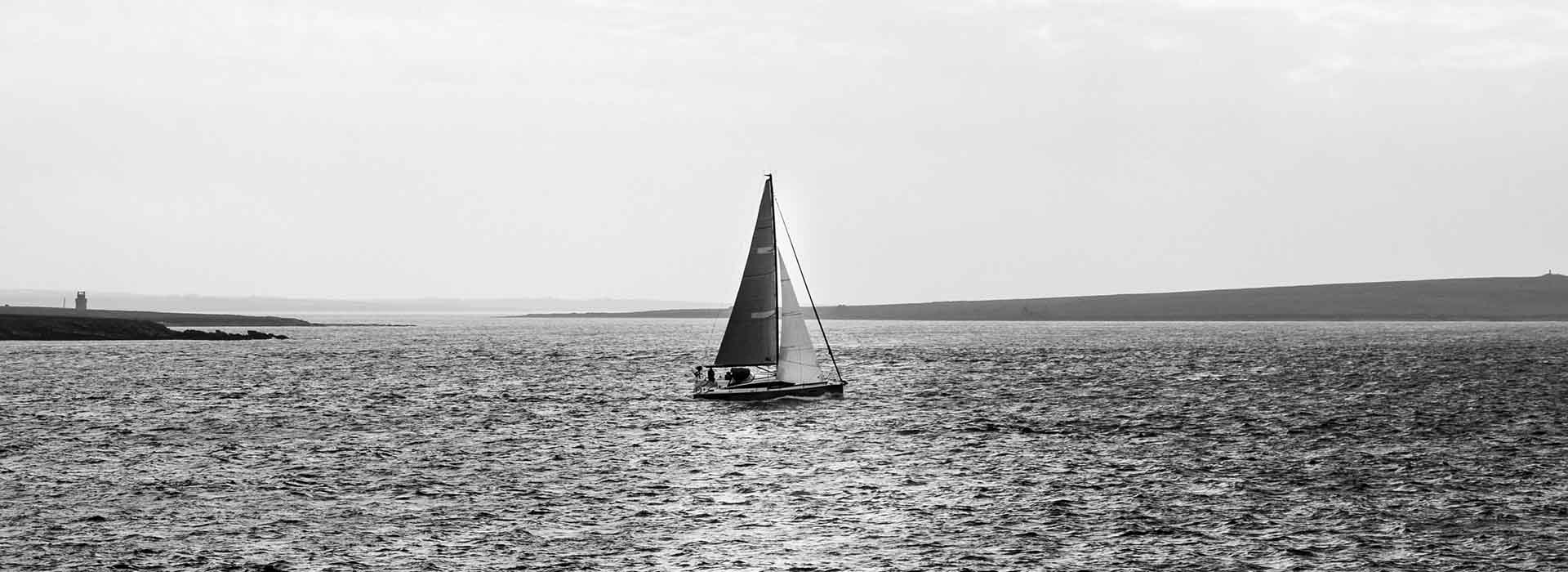 Black and white photograph of sail boat at sea in Orkney