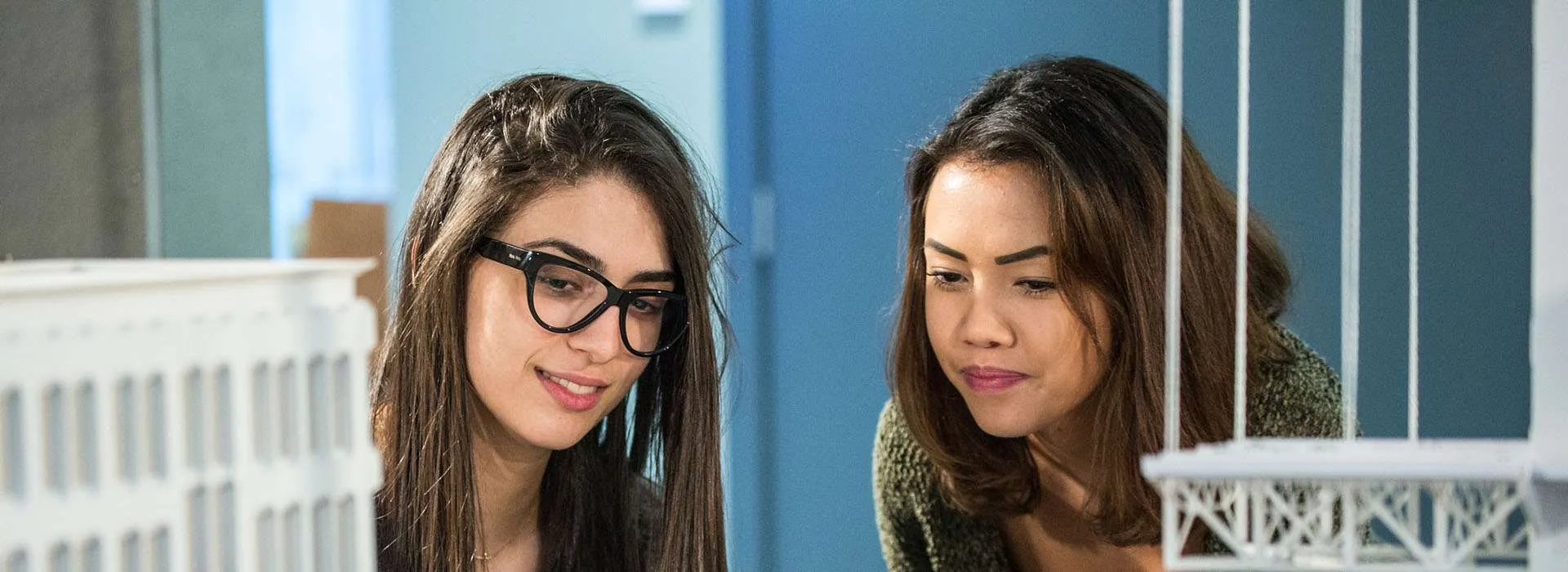 two students looking at architecture models