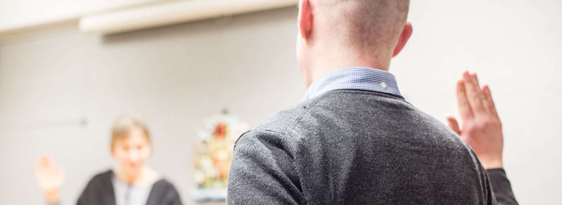 man holding his hand up to swear in