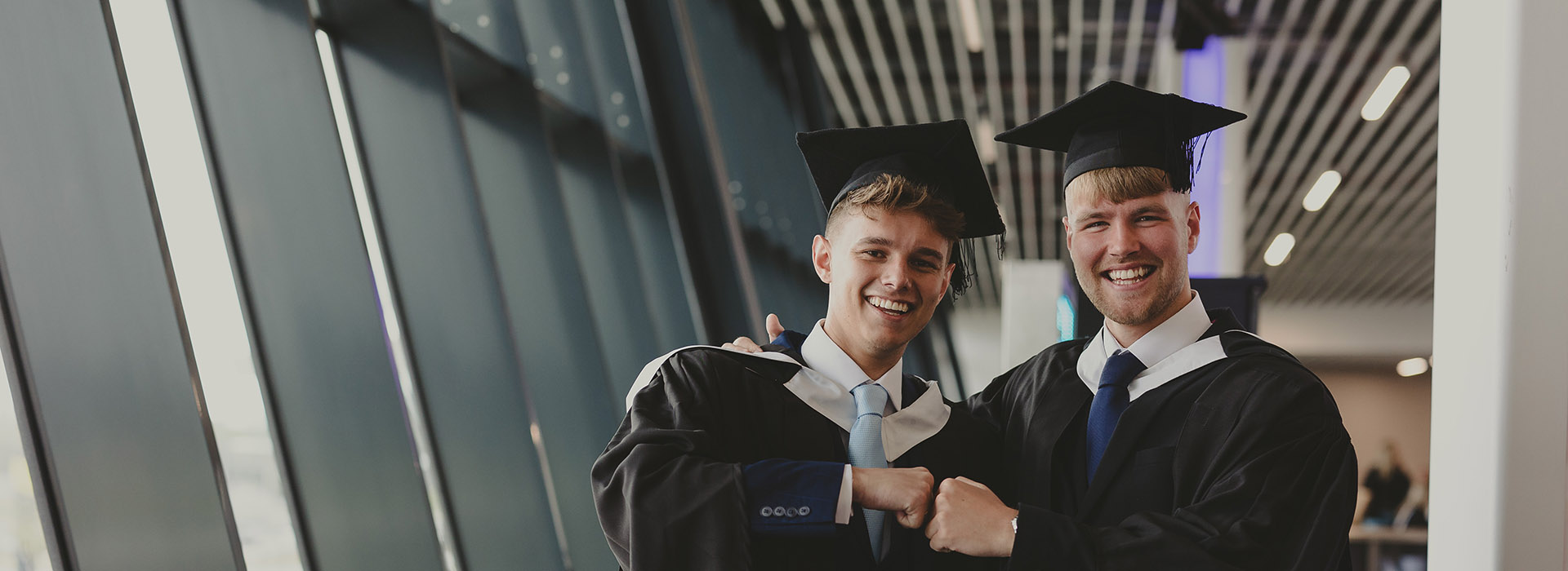 two graduates fist bump