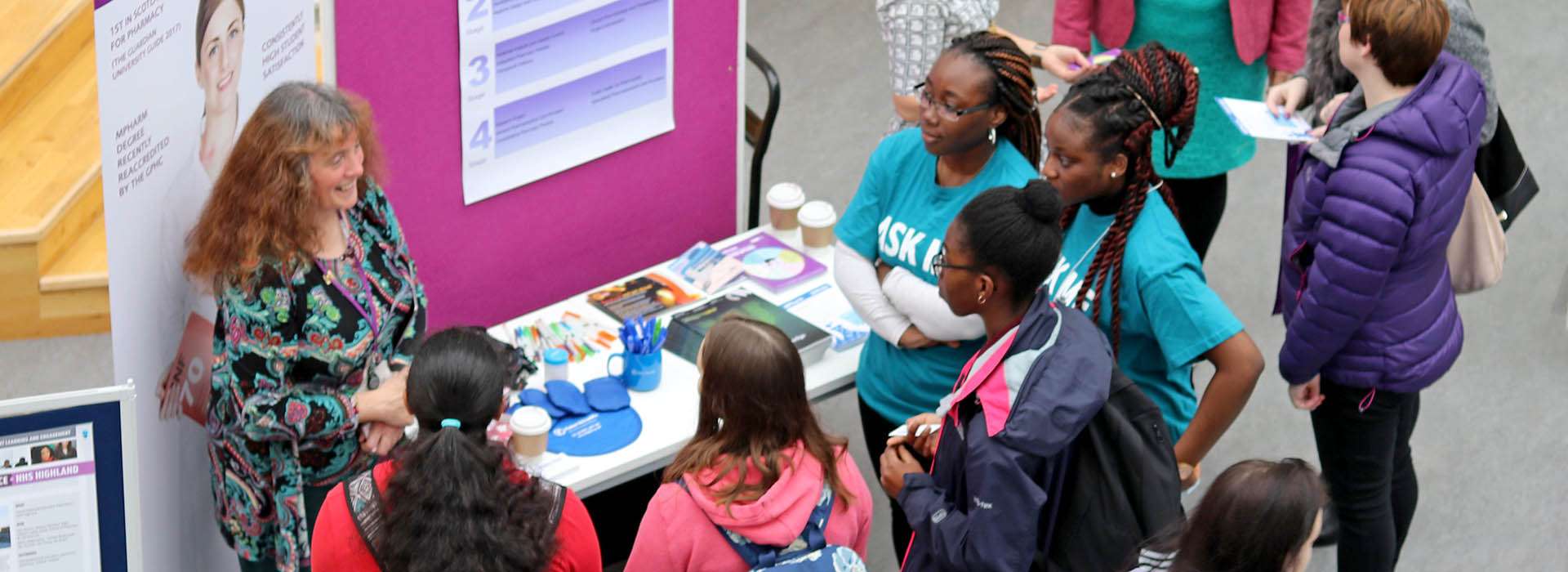 school pupils gathered around an RGU stall