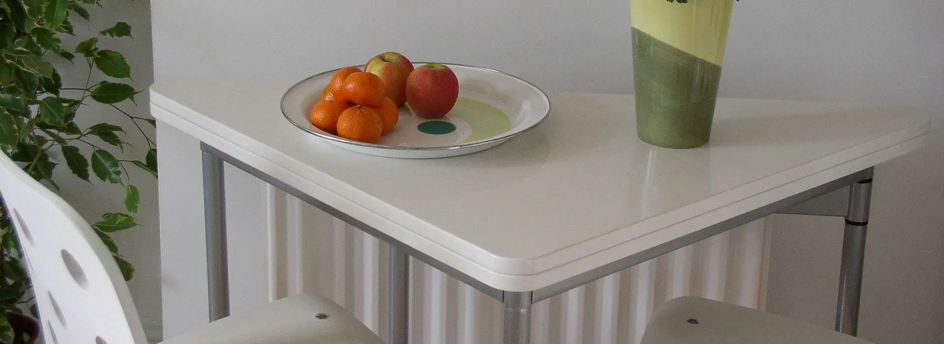 bowl of fruit sitting next to flower vase