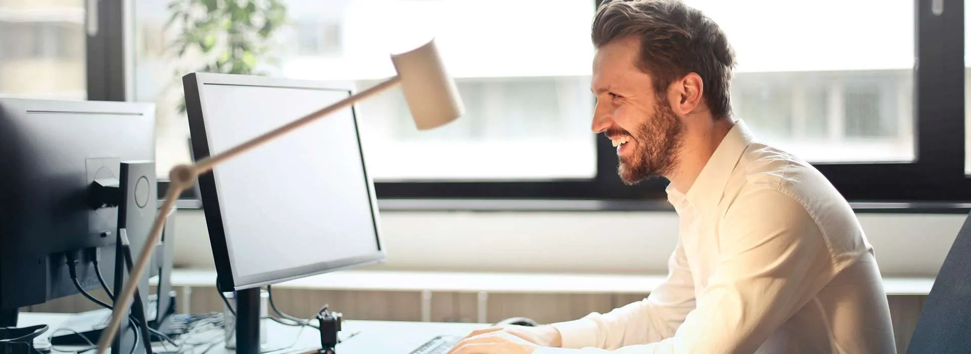 man smiling at computer screen