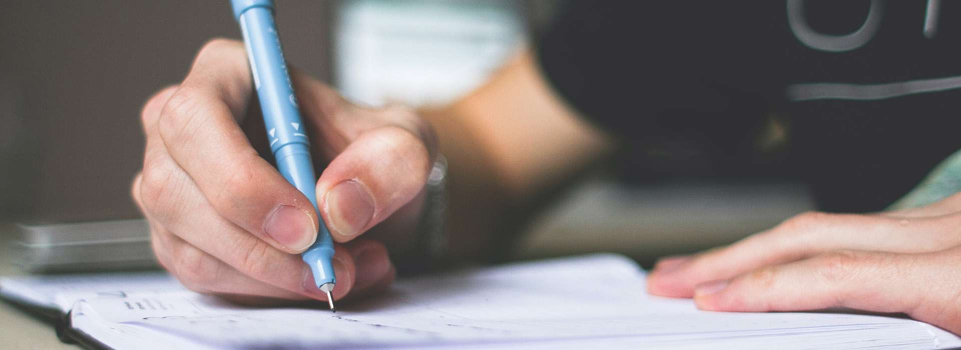 person writing in a notebook