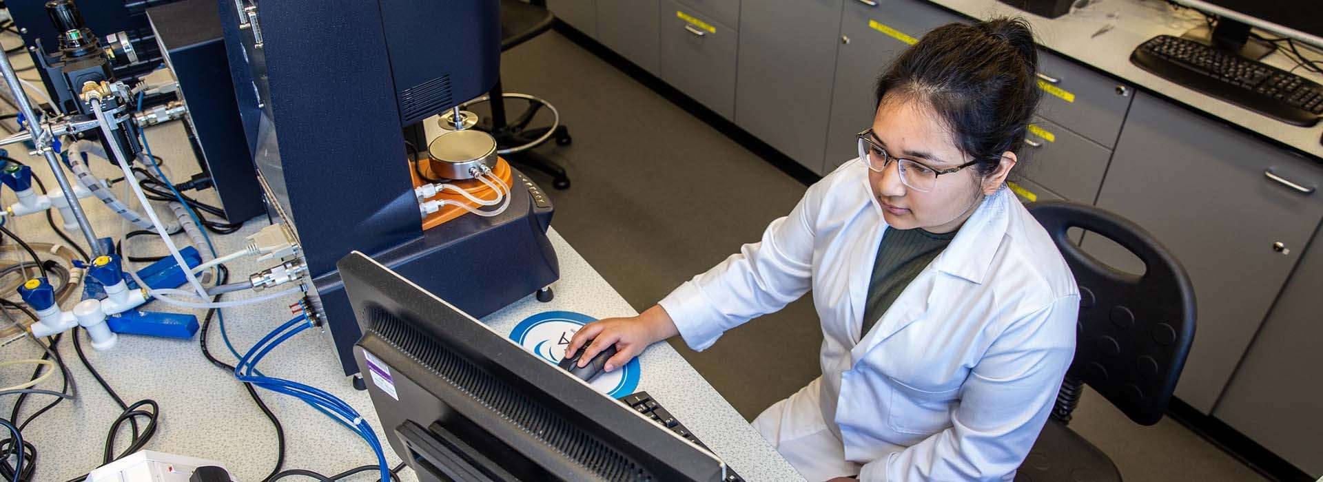 student in laboratory looking at laptop