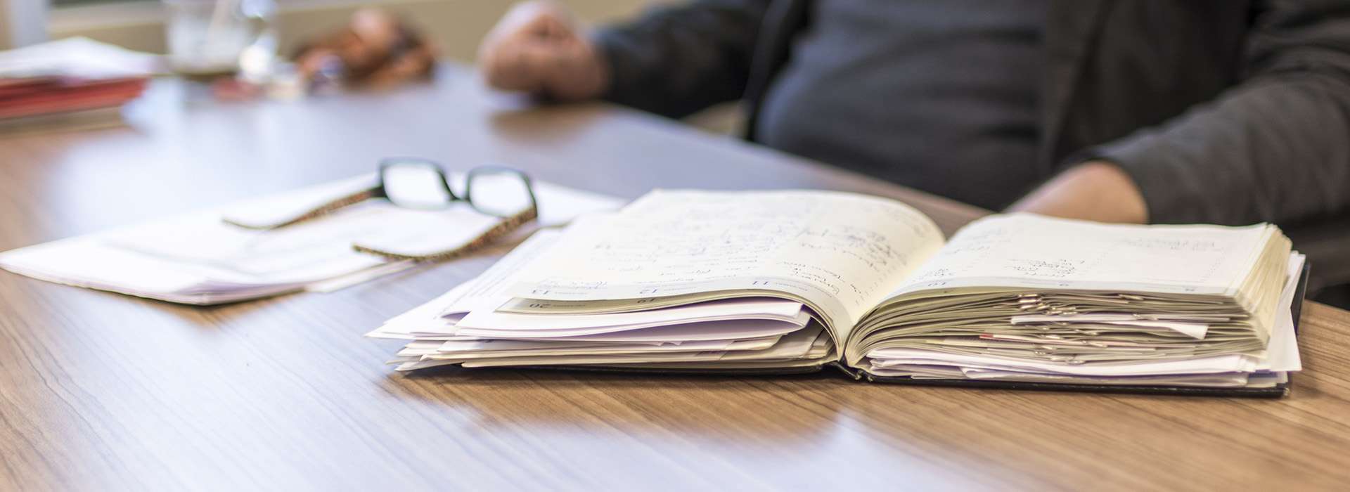 notebook and eyeglasses sitting on table