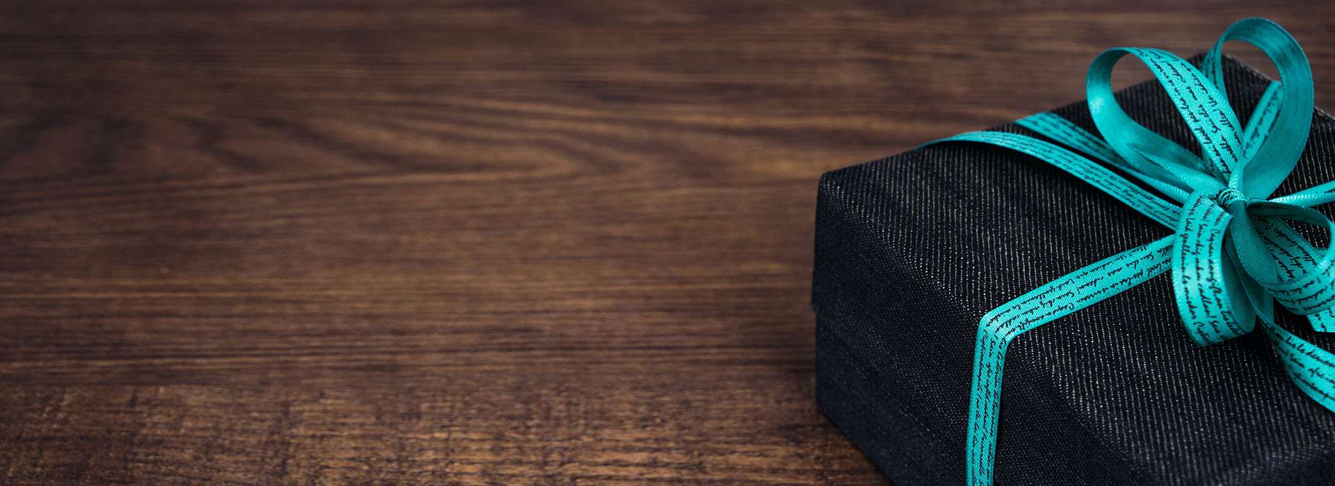 black box gift wrapped with blue ribbon