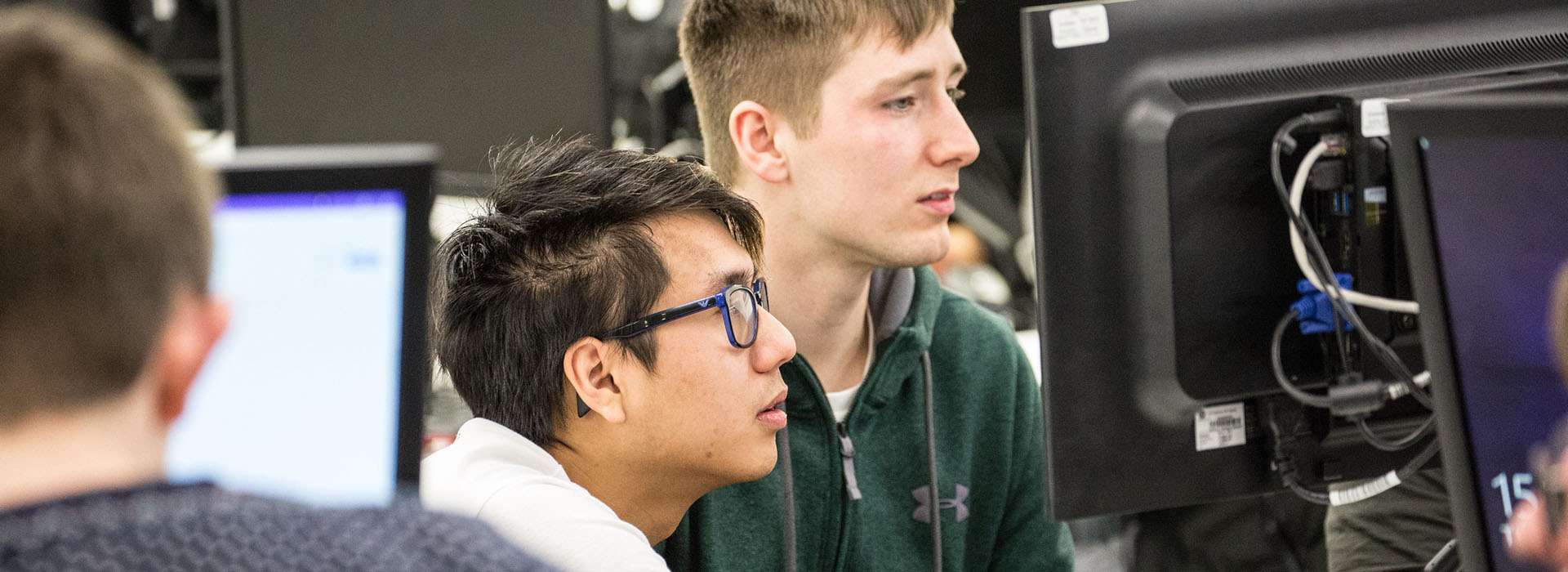 students looking at monitor in computer lab