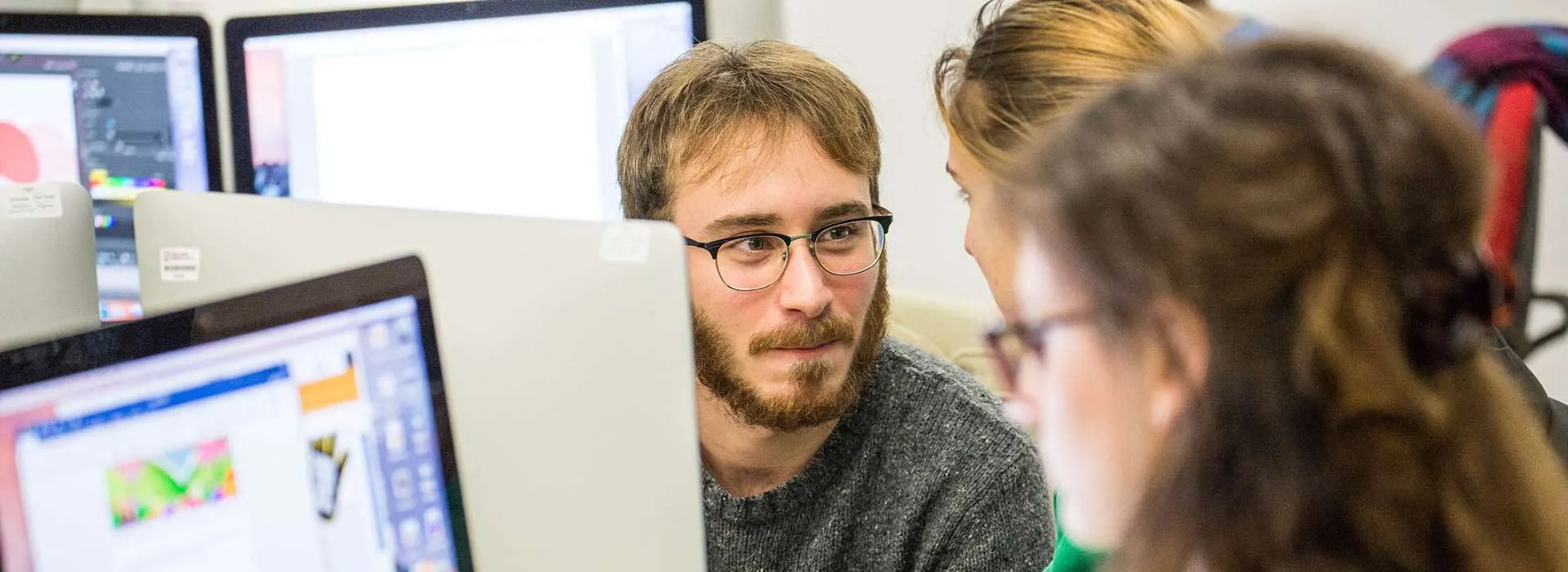 students chatting next to a computer