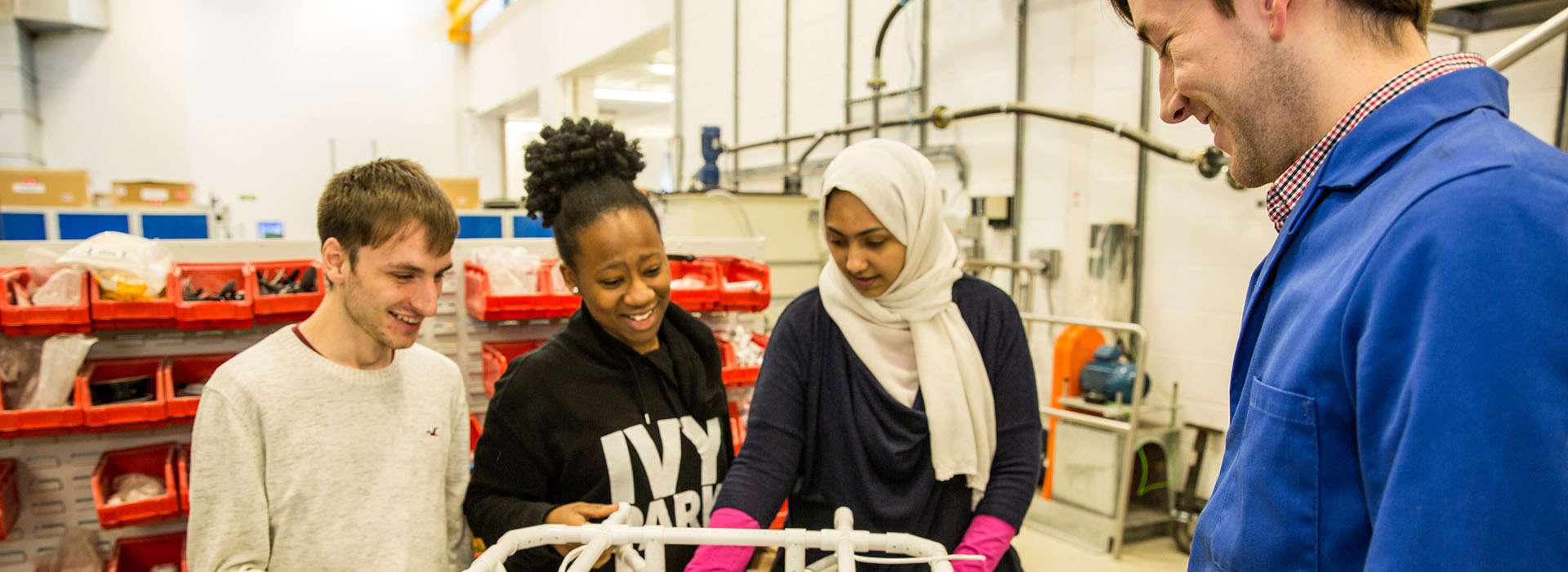 students standing next to ROV frame and 3D printed objects