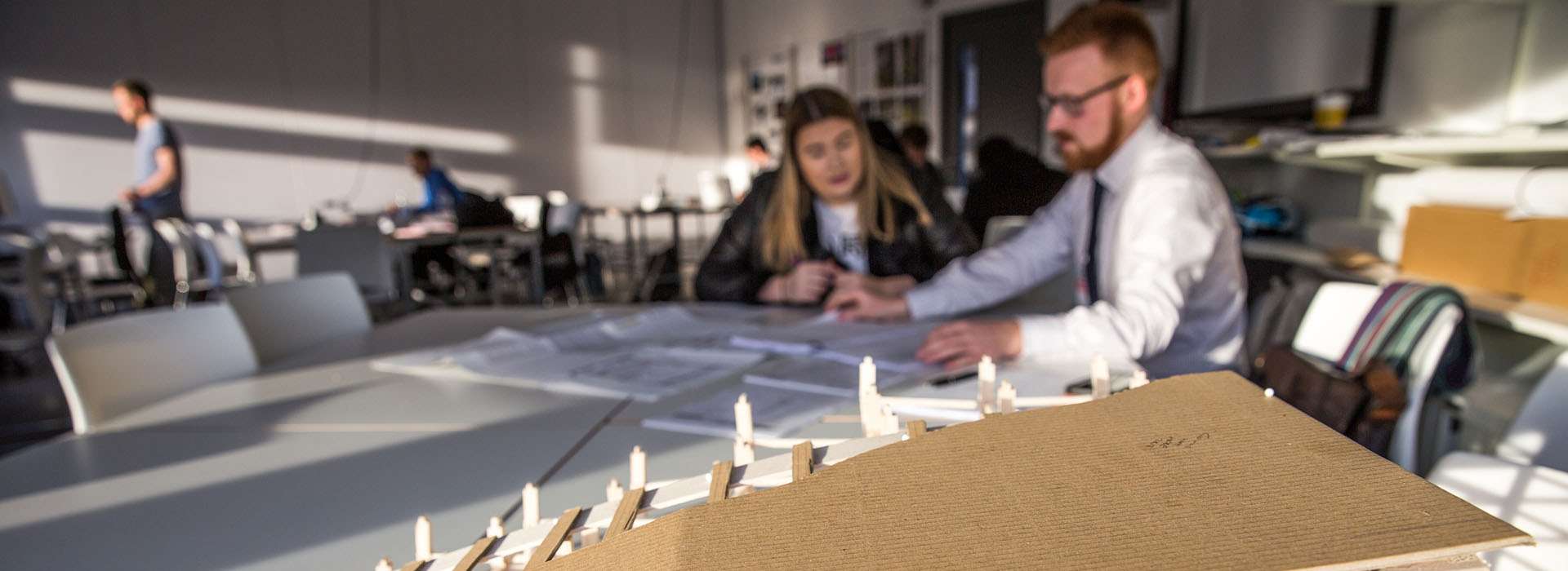 people chatting next to structural model