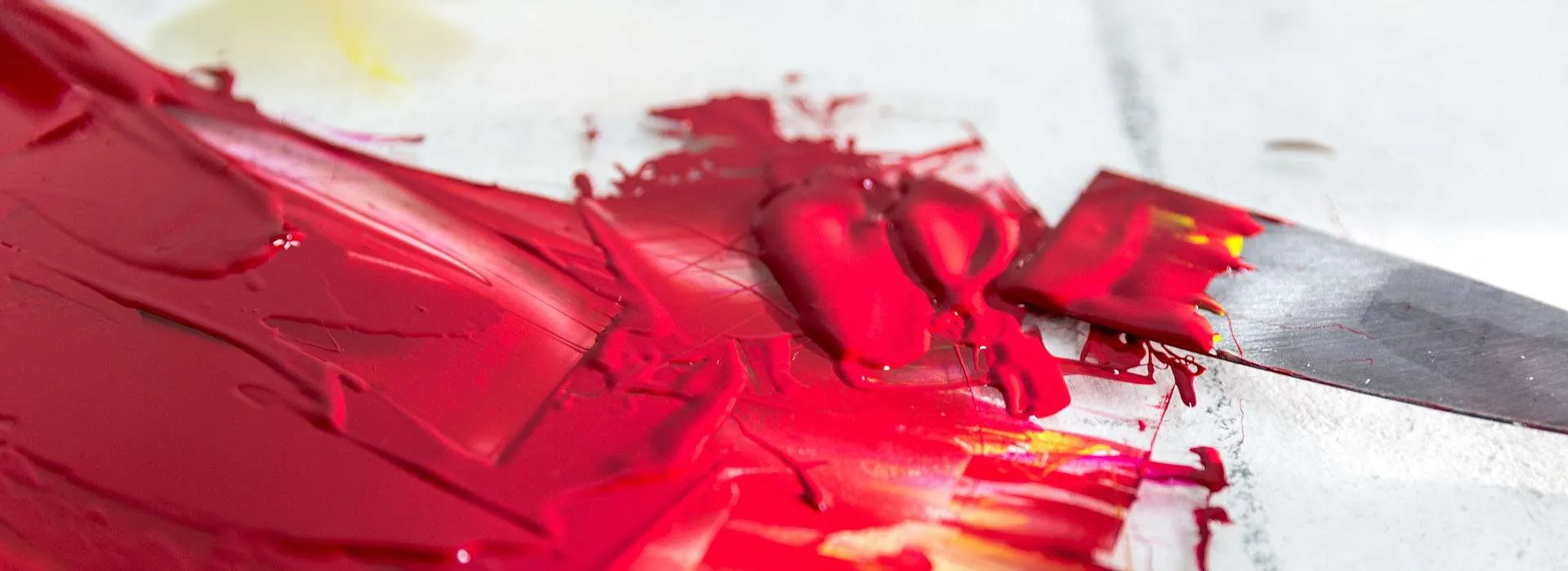 thick red paint on a canvas with a palette knife