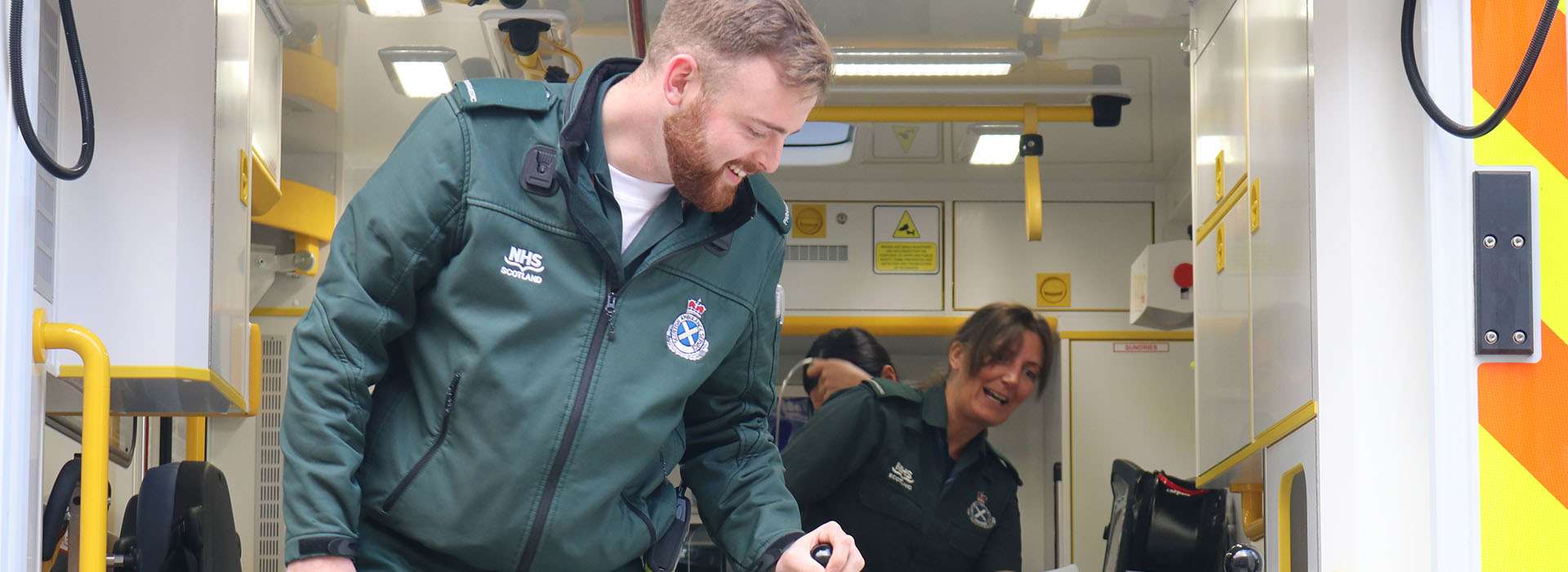 two paramedics smiling in an ambulance