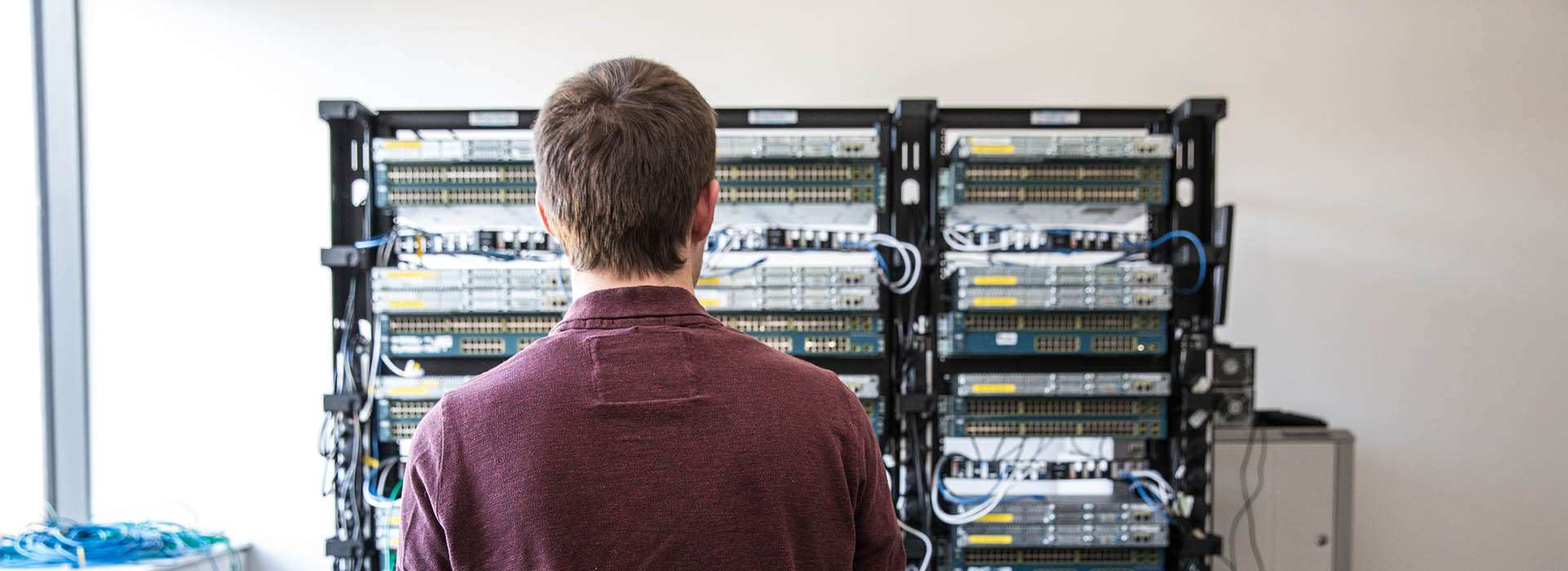 man looking at servers in Cisco Networking Lab
