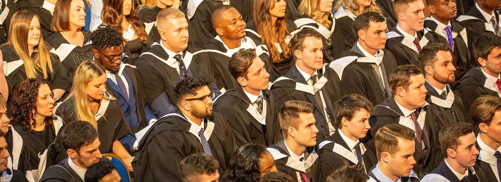 graduates sitting waiting to graduate