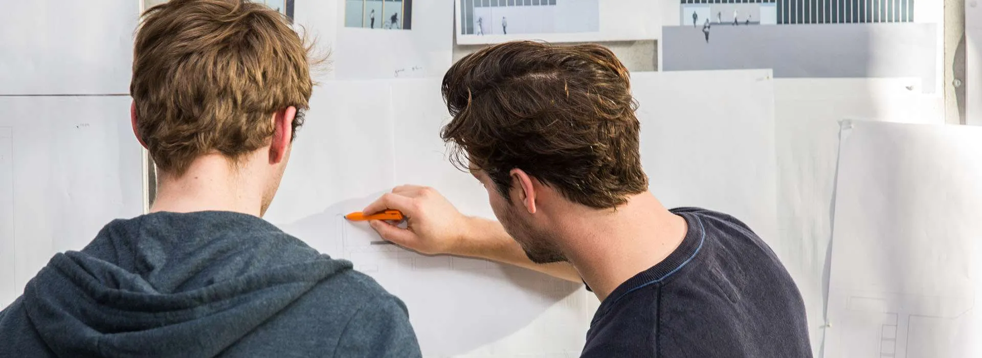 two people looking at a drawing board