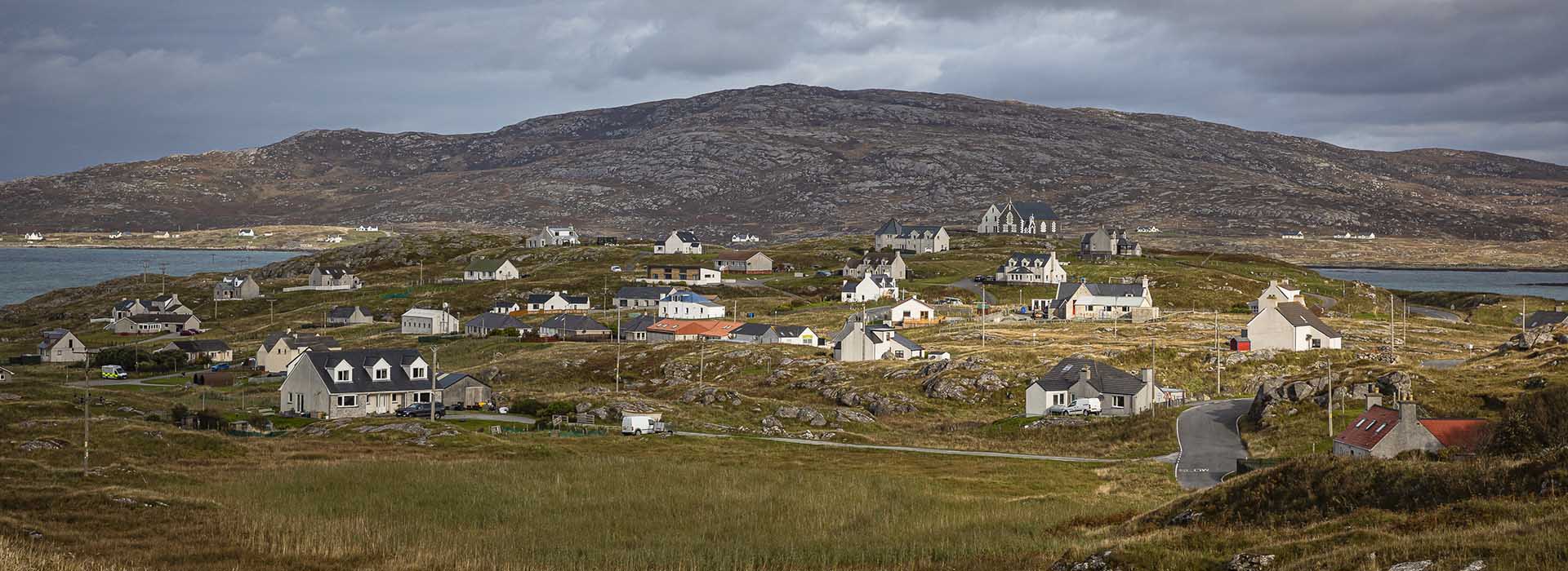 houses dotted about a green landscape in orkney
