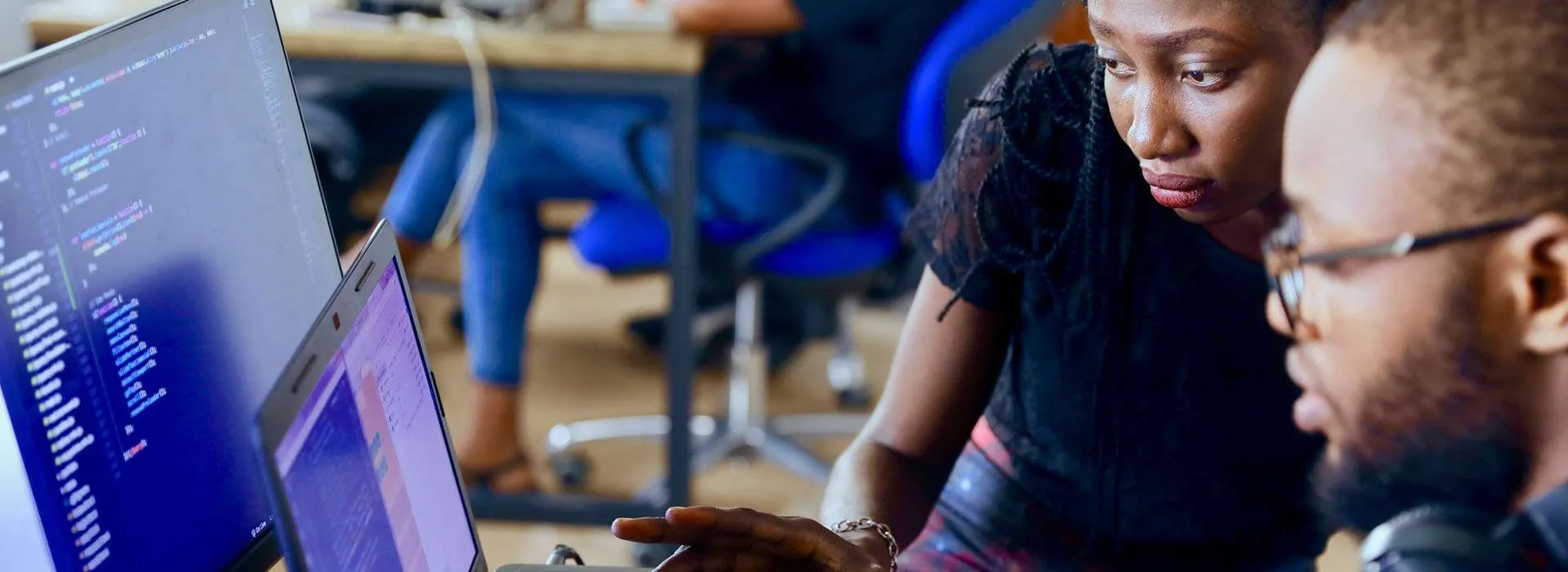 two students looking at code on a monitor