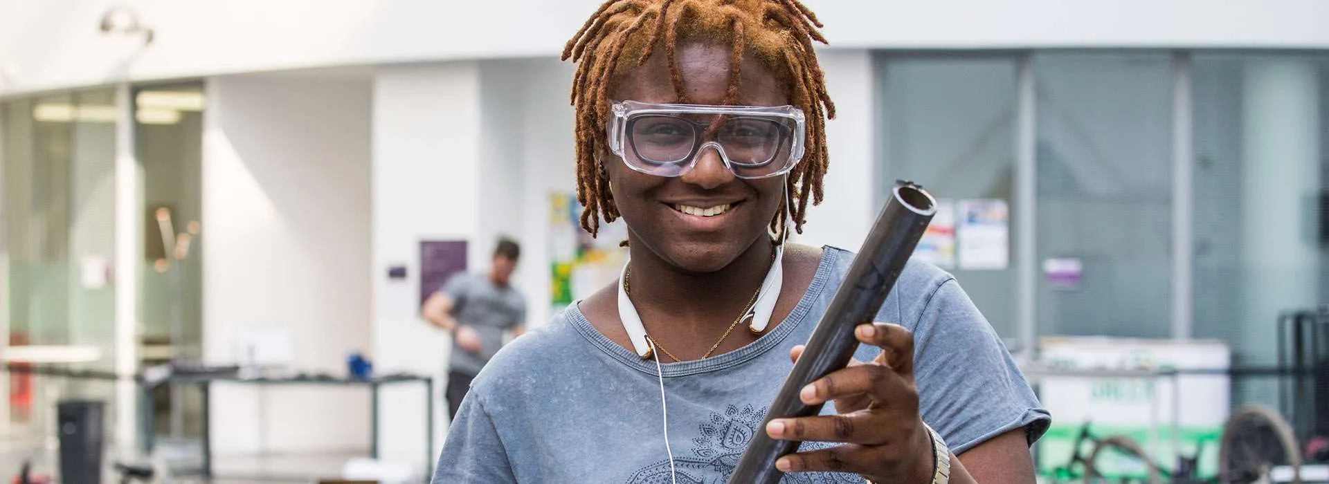 student holding pipe as part of engineering project