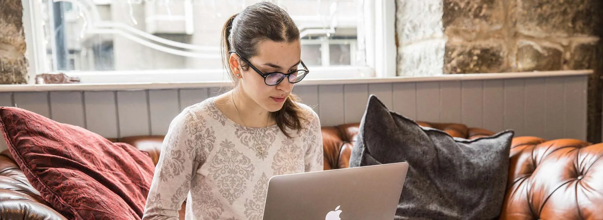 woman looking at laptop in coffee shop