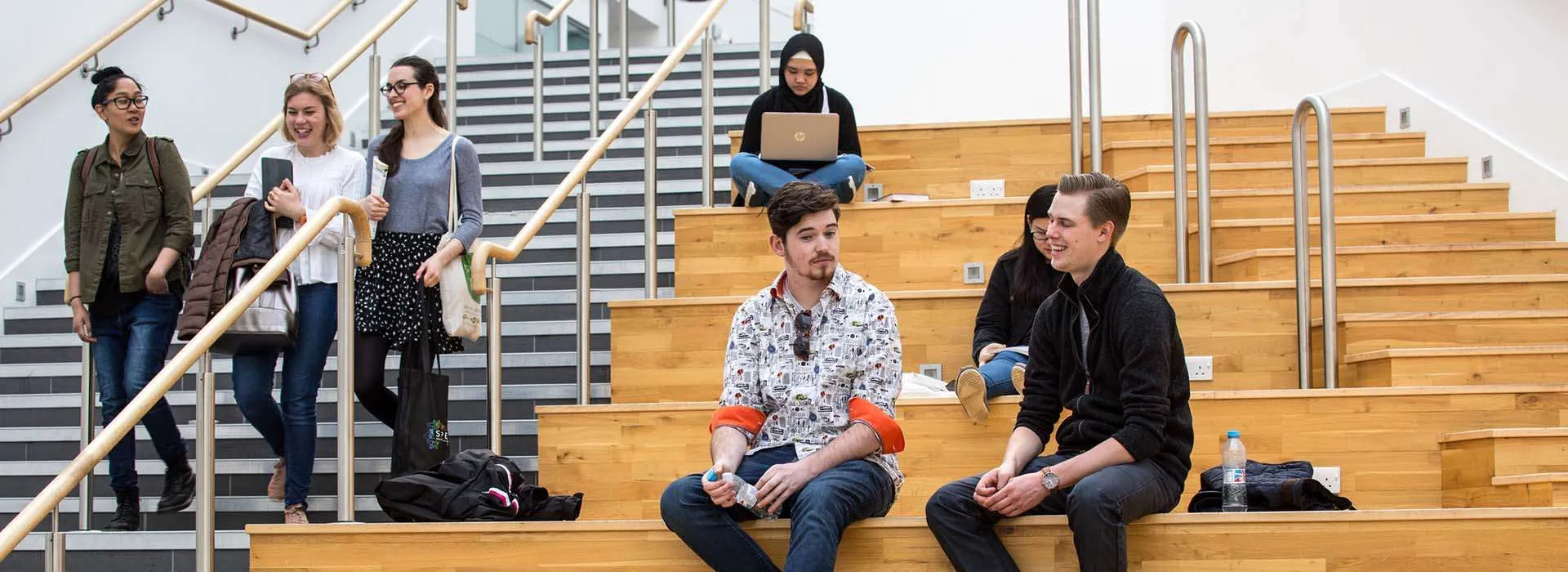 students chatting on large wooden steps