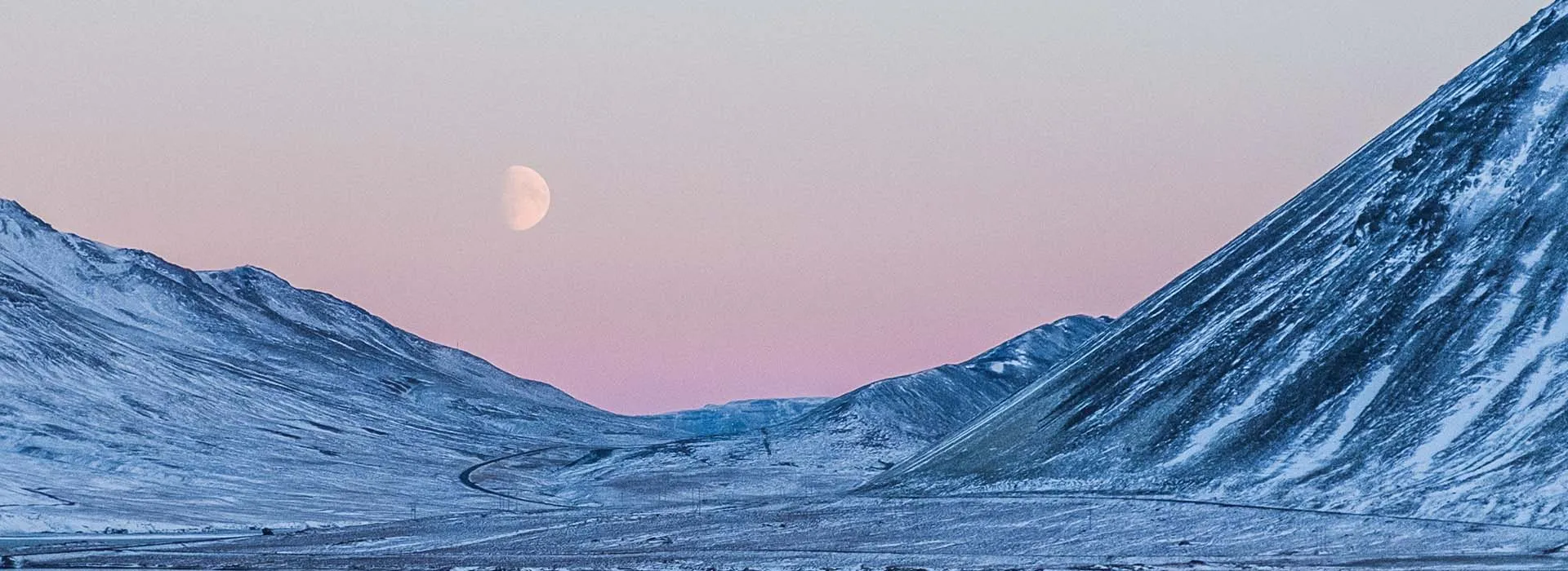 mountains in the Arctic with moon in sky