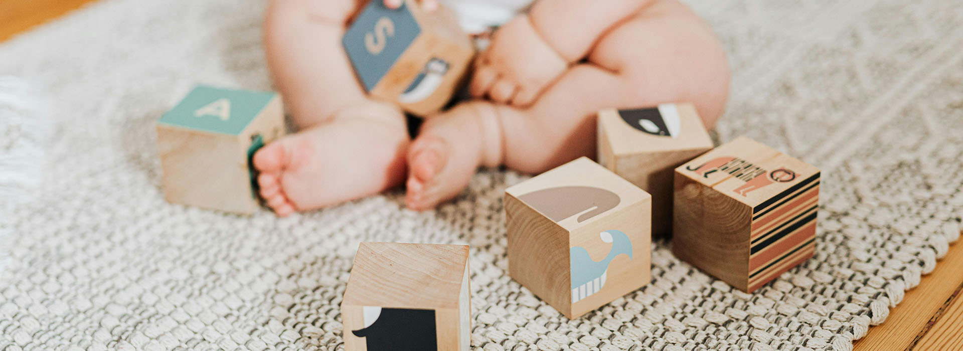 baby sat on the floor playing with blocks