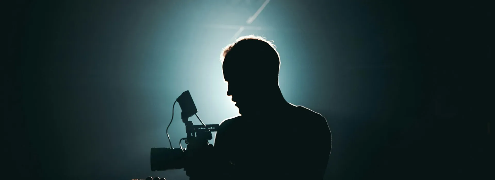 sillhouette of a man standing near a microphone