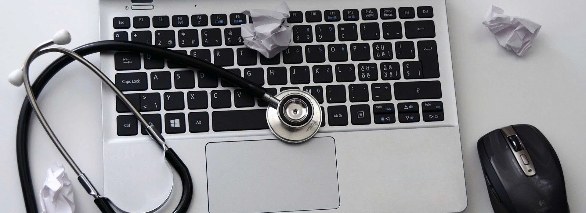 stethoscope sitting on top of a laptop