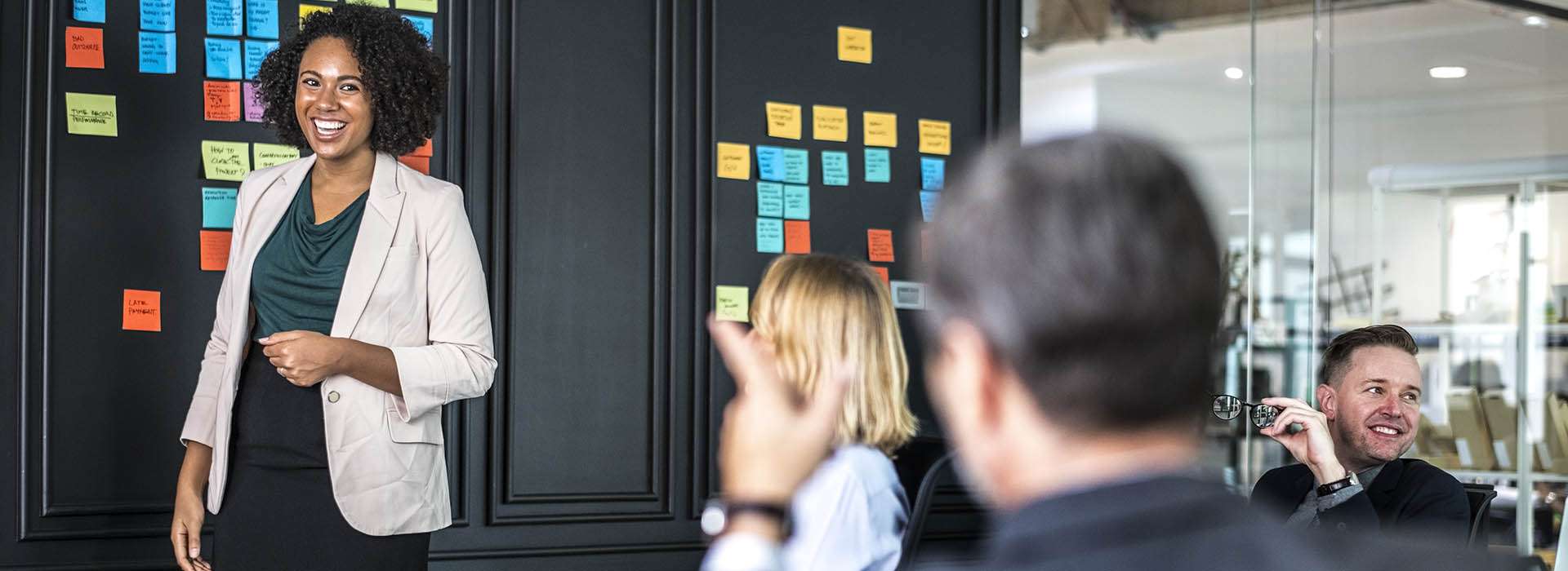 people in a meeting with sticky notes on the wall
