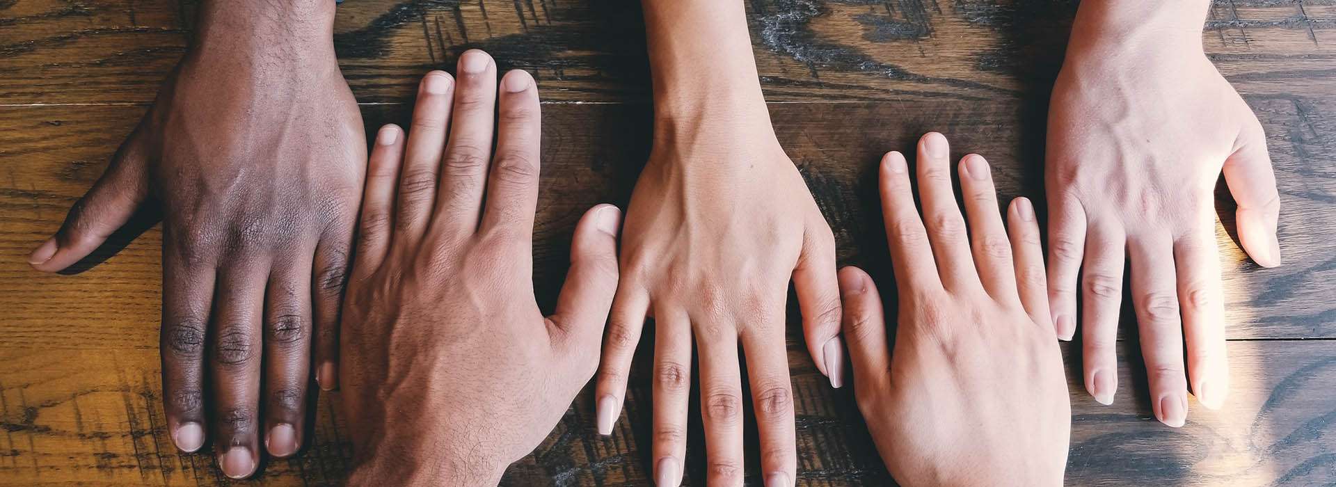 diverse collection of hands on a table