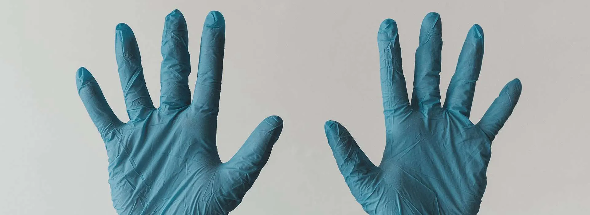blue medical gloves on outstretched hands