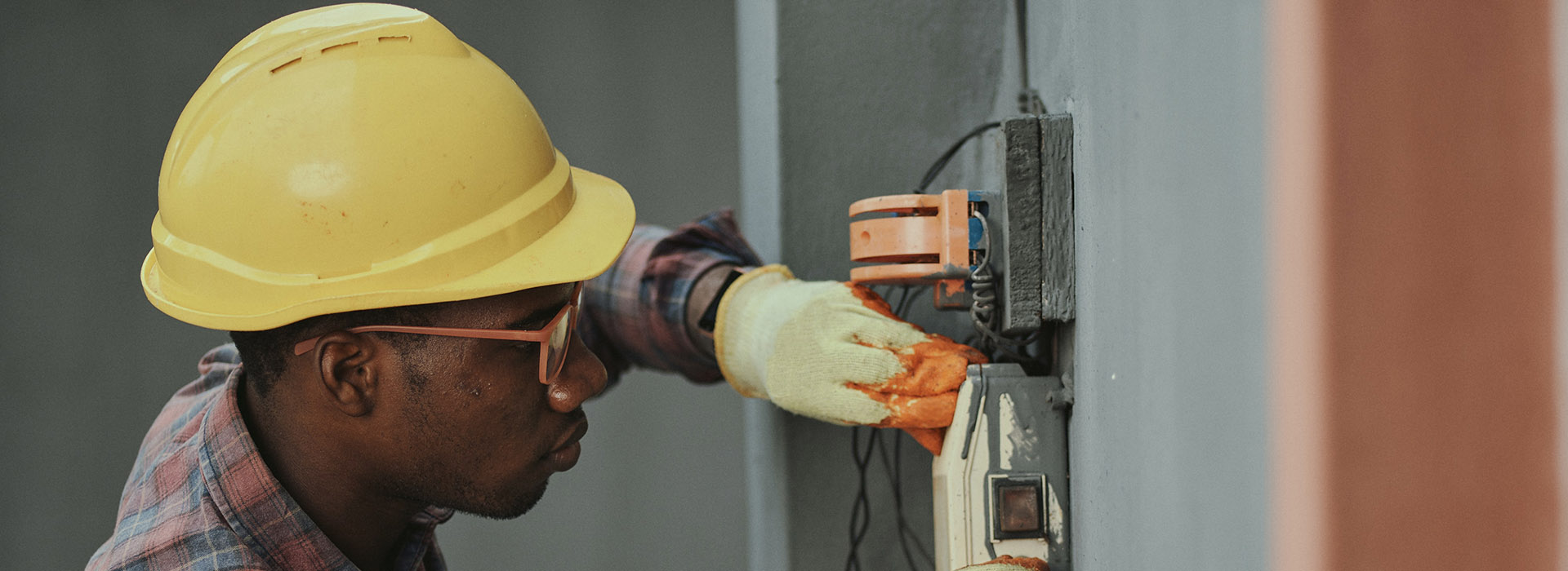 man with hard hat working on electrics