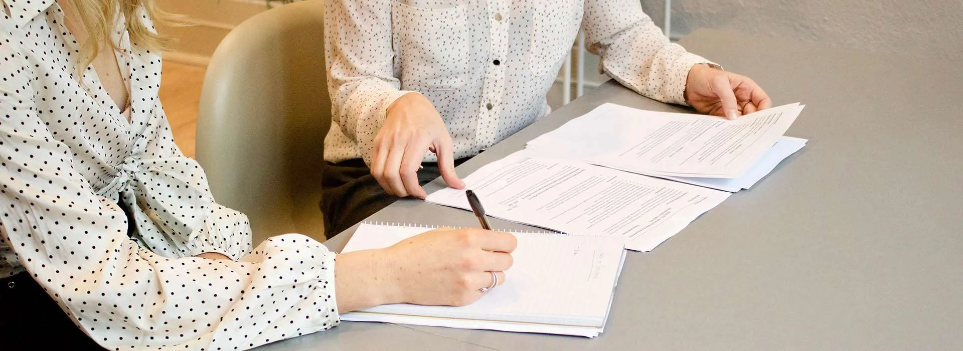 two people reviewing printed documents