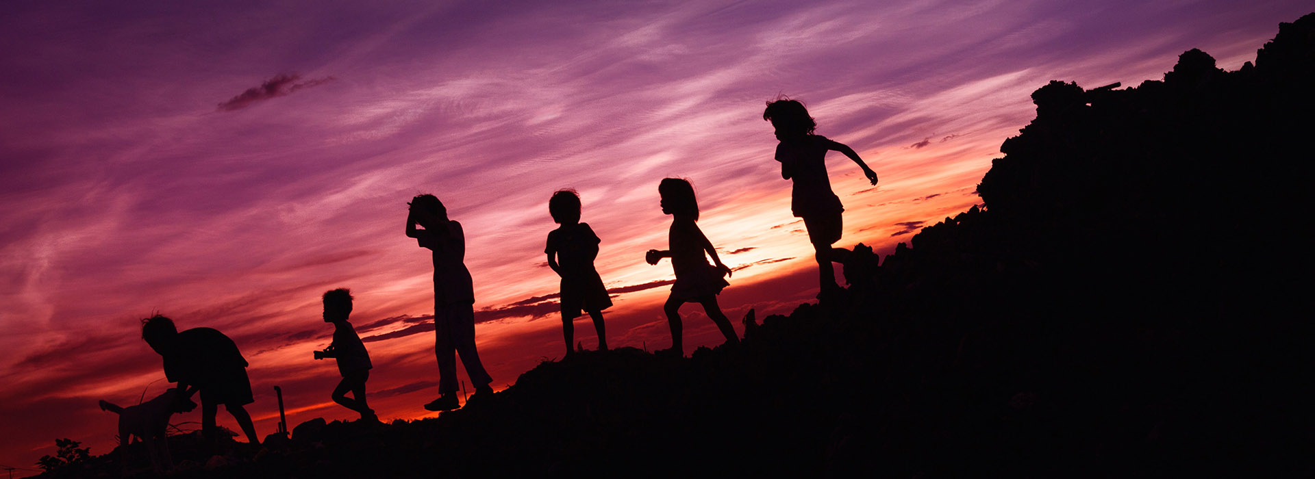 children silhouetted in the sunset