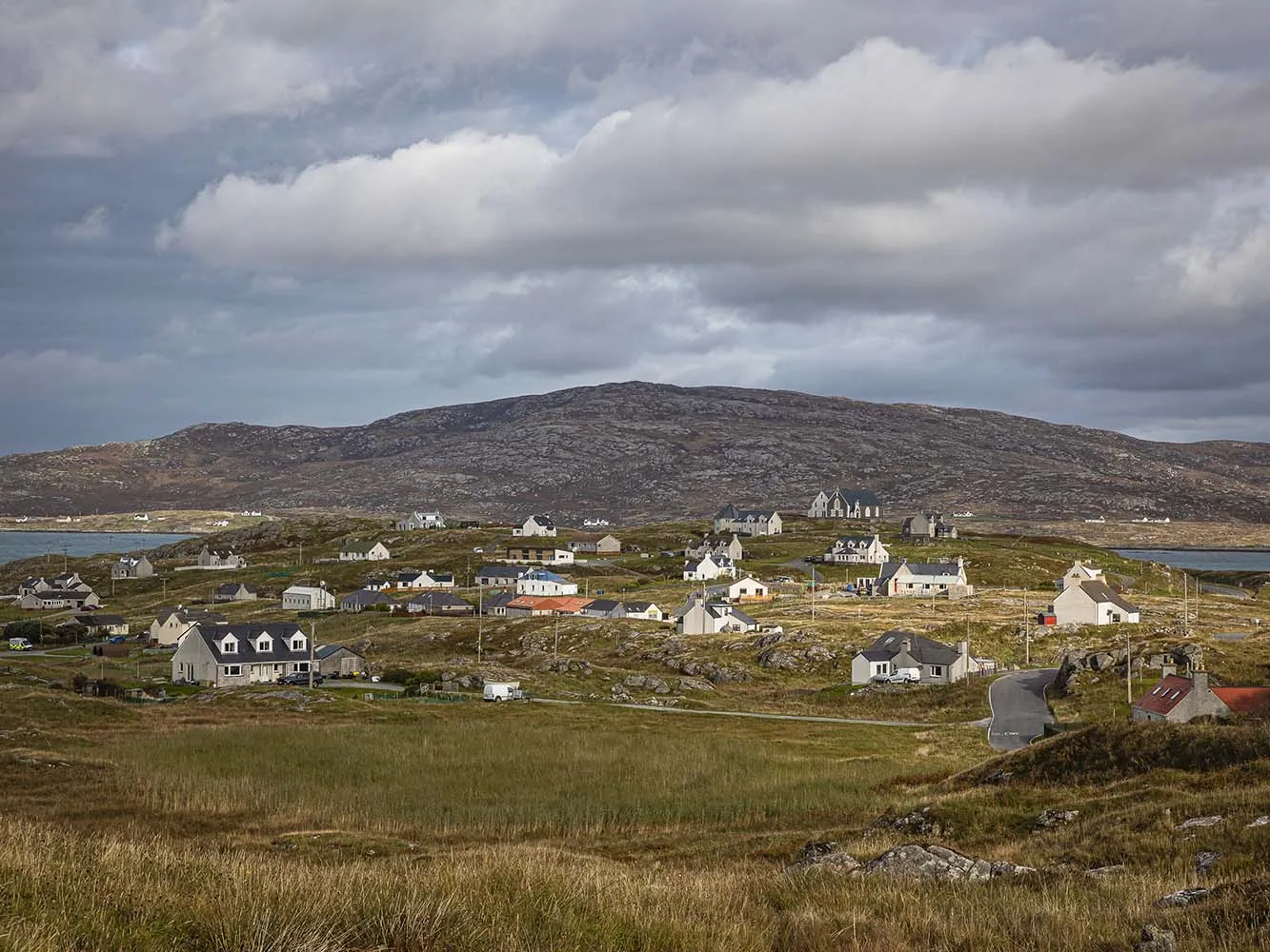 houses dotted about a green landscape in orkney