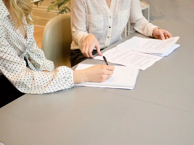 two people reviewing printed documents
