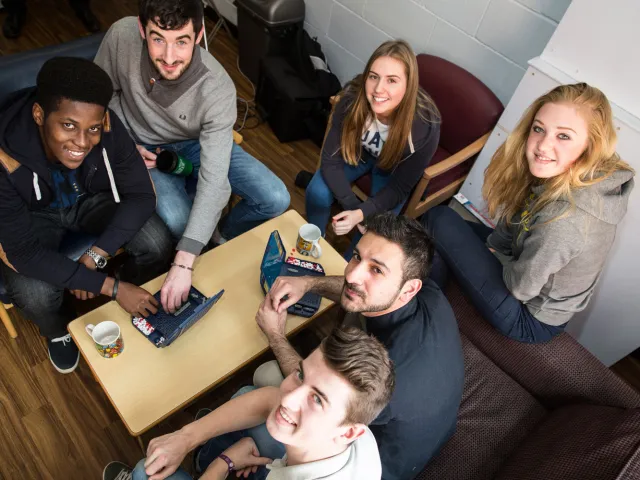students looking up from their study table smiling