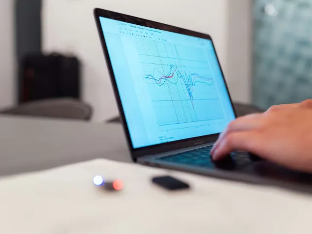 person using a laptop with a graph on the screen