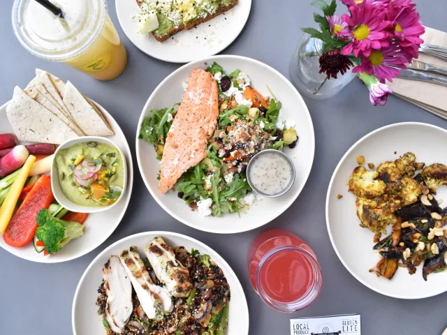 healthy meals on a table with salmon, salad and vegetables