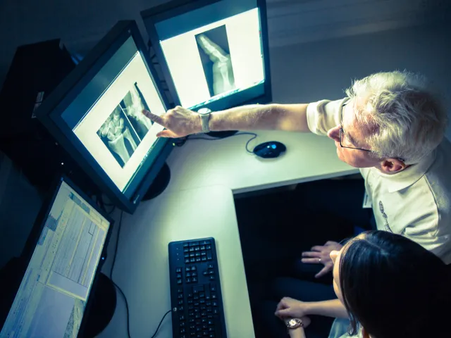 person pointing to an x-ray on a screen