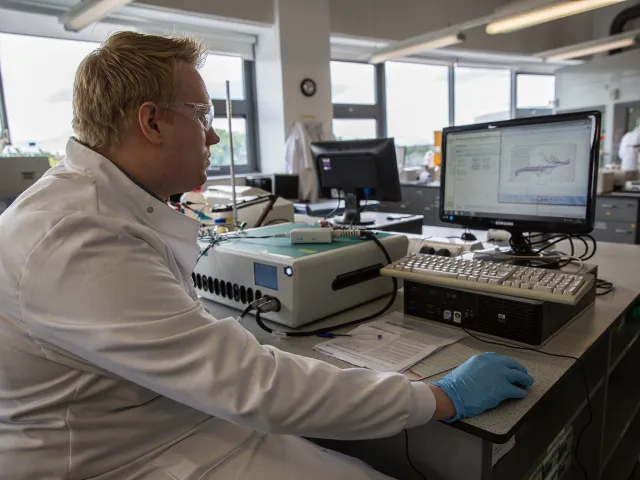 a student wearing safety glasses conducting an electrochemical analysis