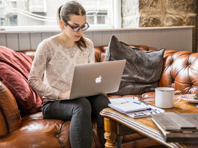 woman looking at laptop in coffee shop