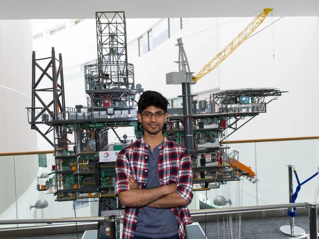 student in front of oil rig model
