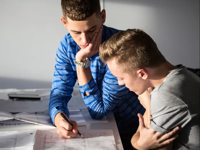 two men looking over technical drawings
