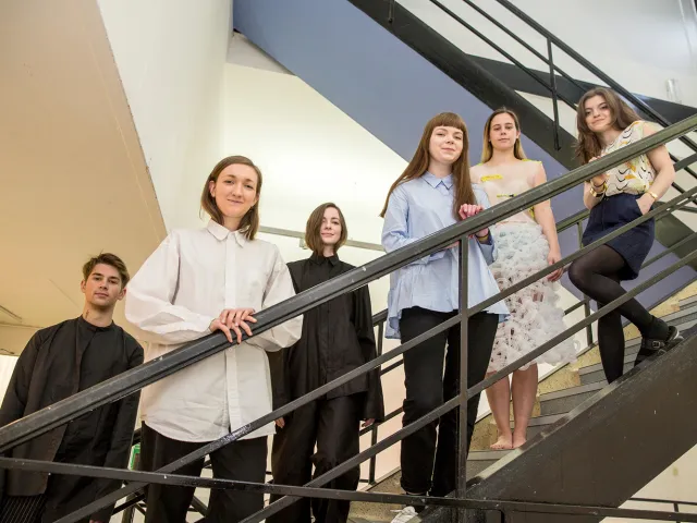 students standing on stairs looking down