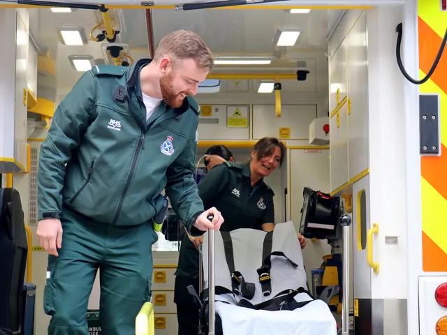 two paramedics smiling in an ambulance