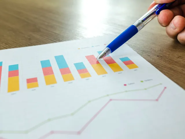 pen pointing at graphs on paper